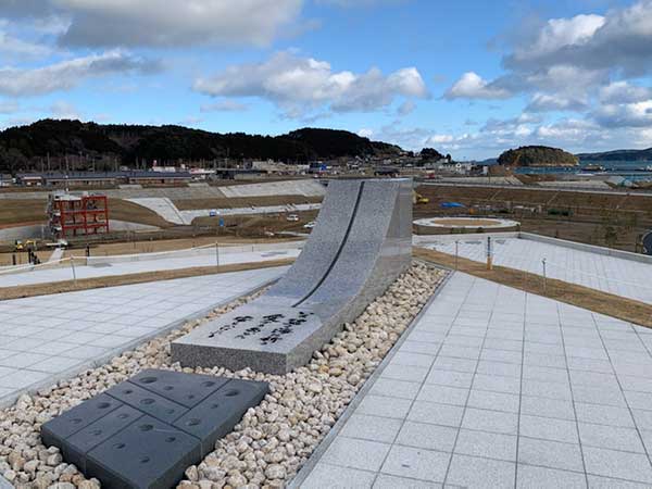 防災庁舎横の祈念公園の上に石碑